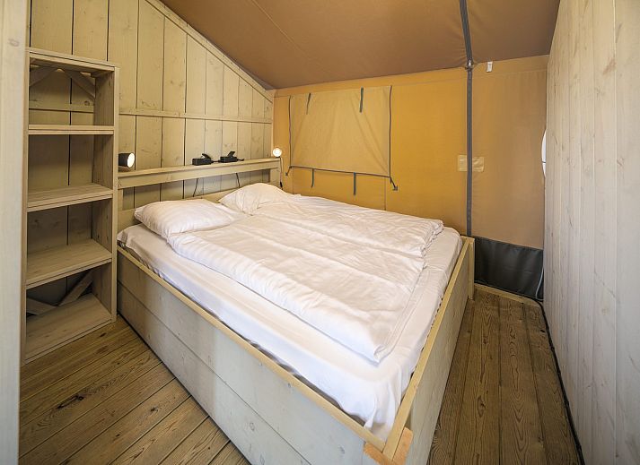 Veranda van de Safaritent Ranger in Lathum, Gelderland, met uitzicht op het water en de groene omgeving.