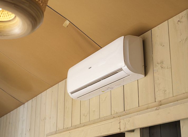 Terras van Safaritent Ranger in Lathum, Gelderland, met comfortabele zitplaatsen en uitzicht op de rivier.