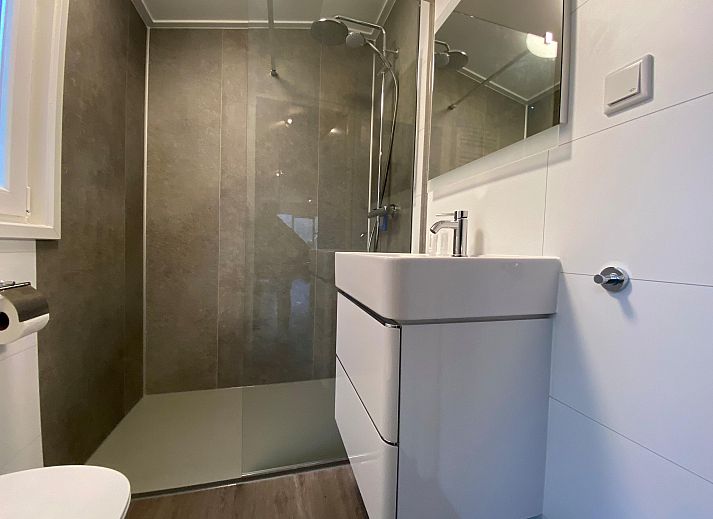 Gemtliches Wohnzimmer in einem freistehenden Haus in Arnheim, Gelderland, mit komfortabler Sitzecke und Esstisch, ideal fr einen entspannten Urlaub.