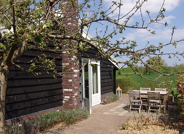 Ferienhaus in Culemborg, Gelderland mit charmanter Holzfassade und gruener Hecke im Rivierengebied.