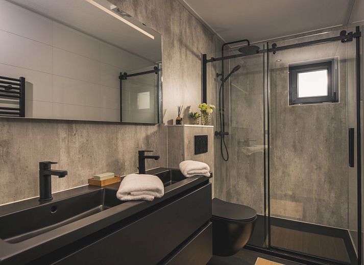 Terrasse mit bequemem Loungesofa im Ferienhaus MarinaPark Bad Nederrijn in Maurik, Gelderland mit Blick auf den Fluss.