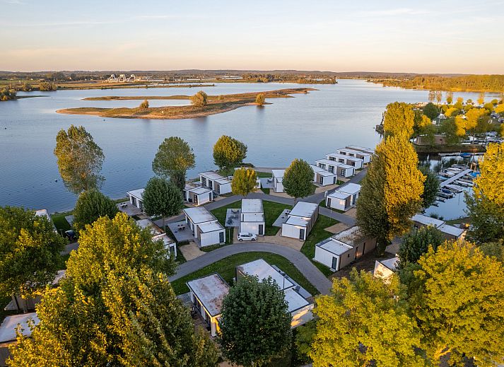 Gemuetliches Wohnzimmer im Ferienhaus MarinaPark Bad Nederrijn, Maurik, Gelderland mit Flussblick und moderner Einrichtung.