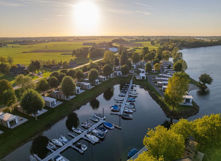 Stijlvol terras bij Vakantiehuis MarinaPark Bad Nederrijn in Maurik, Gelderland, met comfortabele zitplaatsen en parasol.