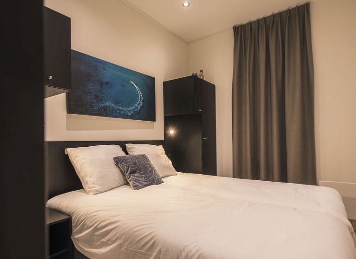 Stijlvol terras bij Vakantiehuis MarinaPark Bad Nederrijn in Maurik, Gelderland, met comfortabele zitplaatsen en parasol.