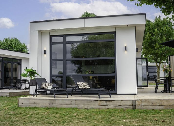 Terras van Vakantiehuis MarinaPark Bad Nederrijn in Maurik, Gelderland met comfortabele zitplaatsen en parasol.