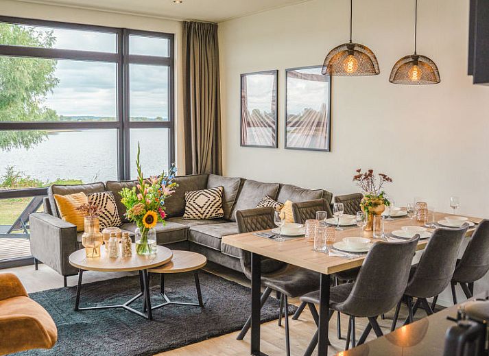 Terras van Vakantiehuis MarinaPark Bad Nederrijn in Maurik, Gelderland met comfortabele zitplaatsen en parasol.