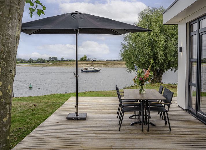 Slaapkamer in Vakantiehuis MarinaPark Bad Nederrijn, Maurik, Gelderland met tweepersoonsbed en toegang tot terras.