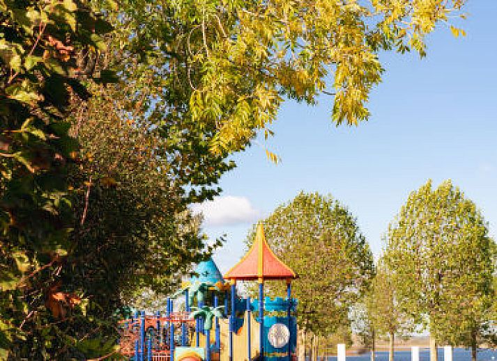 Slaapkamer in Vakantiehuis MarinaPark Bad Nederrijn, Maurik, Gelderland met tweepersoonsbed en toegang tot terras.