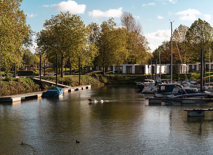 Slaapkamer in Vakantiehuis MarinaPark Bad Nederrijn, Maurik, Gelderland met tweepersoonsbed en toegang tot terras.