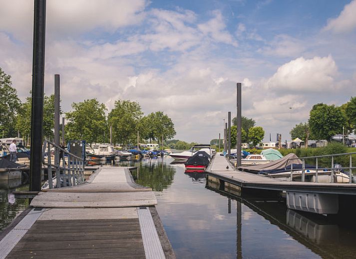 Veranda met ligstoelen bij Vakantiehuis MarinaPark Bad Nederrijn in Maurik, Gelderland met uitzicht op het water.