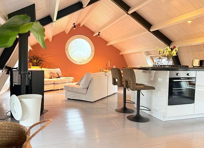 Gezellige binnenruimte van Huisje in Acquoy, vakantiehuis in Rivierengebied, Gelderland, met comfortabele bank en sfeervolle houtkachel.