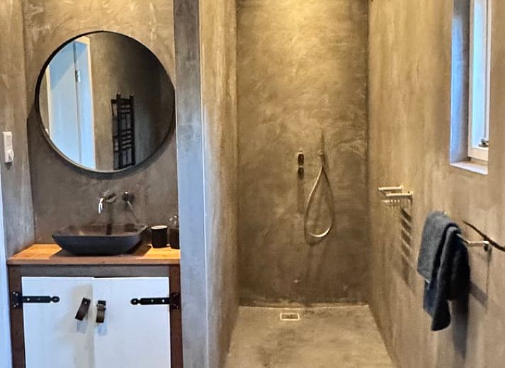 Gezellige binnenruimte van Huisje in Acquoy, vakantiehuis in Rivierengebied, Gelderland, met comfortabele bank en sfeervolle houtkachel.