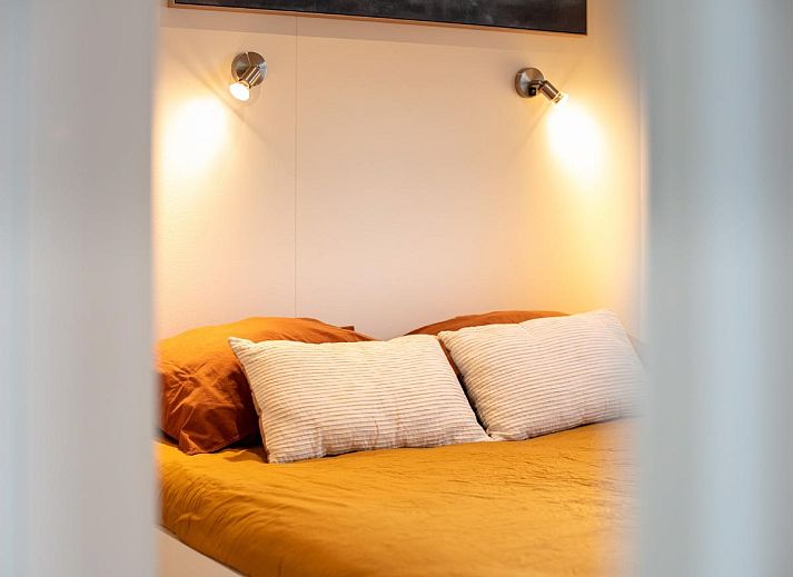 La Serafat Ferienhaus in Maasbommel, Gelderland, schwimmend auf dem Wasser mit Dachterrasse und Sonnenschirm.