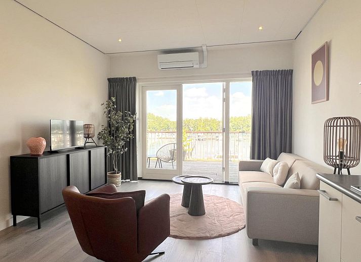 Stilvolles Wohnzimmer im Ferienhaus Havenzicht, Maasbommel, mit bequemem Sofa und moderner Einrichtung in Gelderland.