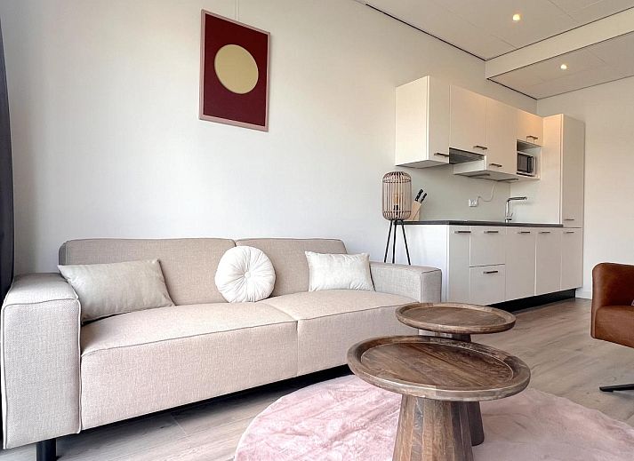 Essecke im Ferienhaus Havenzicht, Maasbommel, mit eleganten rosafarbenen Stuehlen und Blumenschmuck im Rivierengebied, Gelderland.