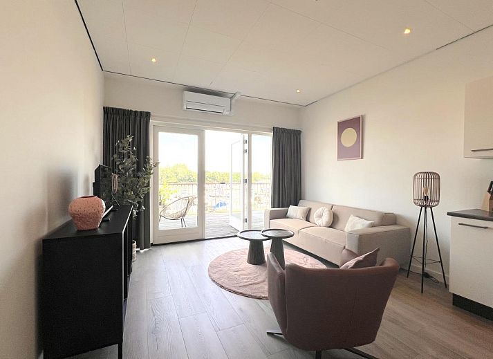 Essecke im Ferienhaus Havenzicht, Maasbommel, mit eleganten rosafarbenen Stuehlen und Blumenschmuck im Rivierengebied, Gelderland.