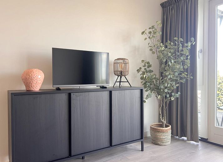 Essecke im Ferienhaus Havenzicht, Maasbommel, mit eleganten rosafarbenen Stuehlen und Blumenschmuck im Rivierengebied, Gelderland.