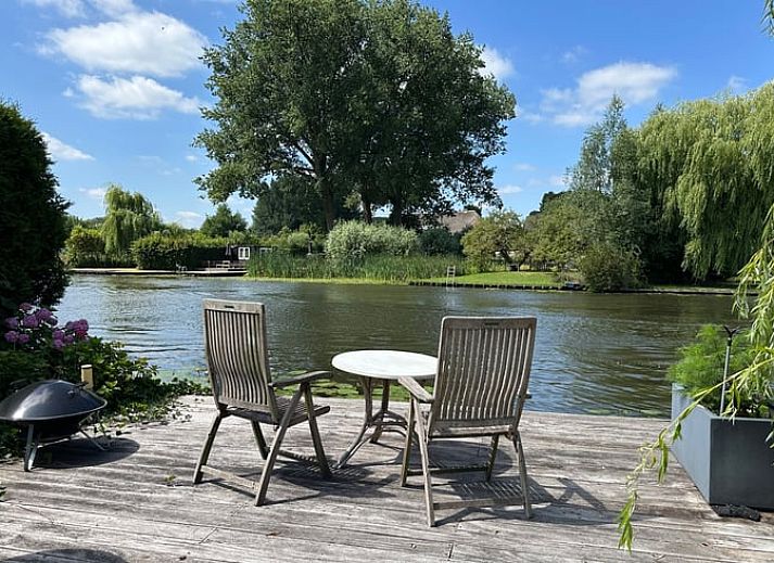Geniet van de ruime veranda van Huisje in Gellicum, een vakantiehuis in het groene Rivierengebied van Gelderland.