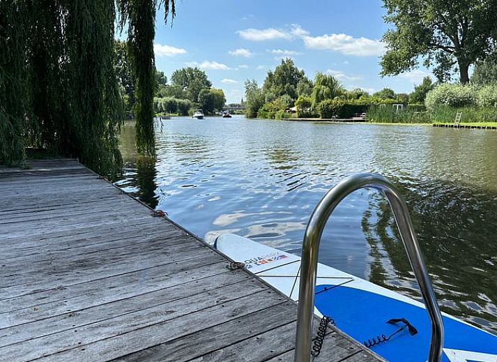 Geniet van de ruime veranda van Huisje in Gellicum, een vakantiehuis in het groene Rivierengebied van Gelderland.