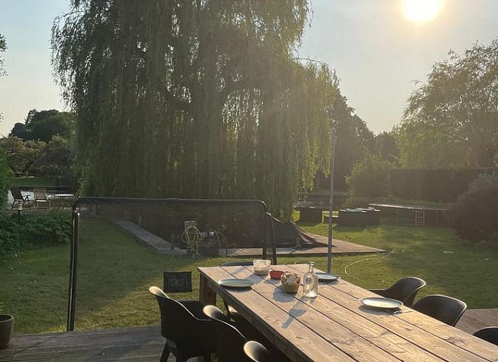Geniet van de serene tuin van Huisje in Gellicum, vakantiehuis in het Rivierengebied, Gelderland, omgeven door weelderige natuur.