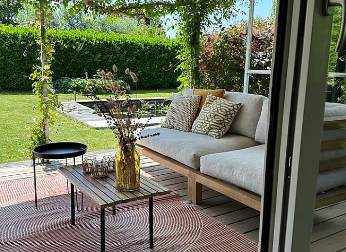 Geniet van de serene tuin van Huisje in Gellicum, vakantiehuis in het Rivierengebied, Gelderland, omgeven door weelderige natuur.