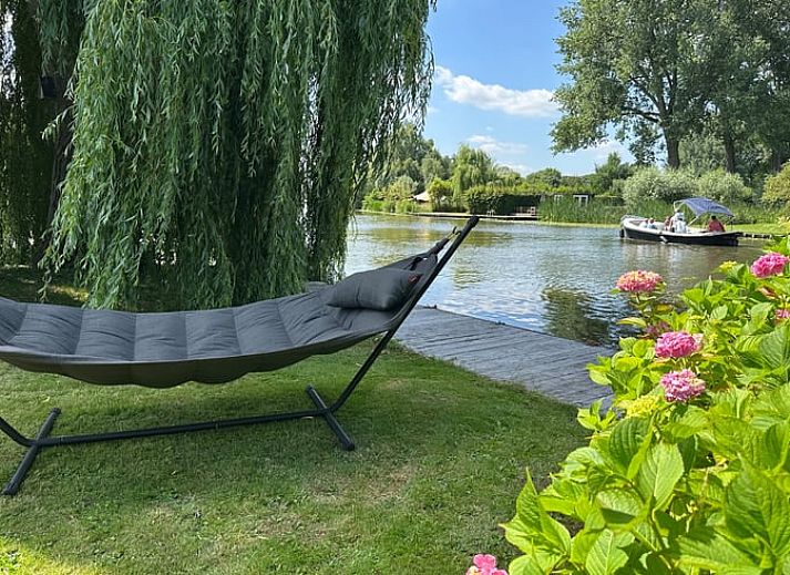 Gezellige keuken en eetruimte in Huisje in Gellicum, vakantiehuis in het Rivierengebied, Gelderland, met een rustieke houten tafel en stijlvolle inrichting.