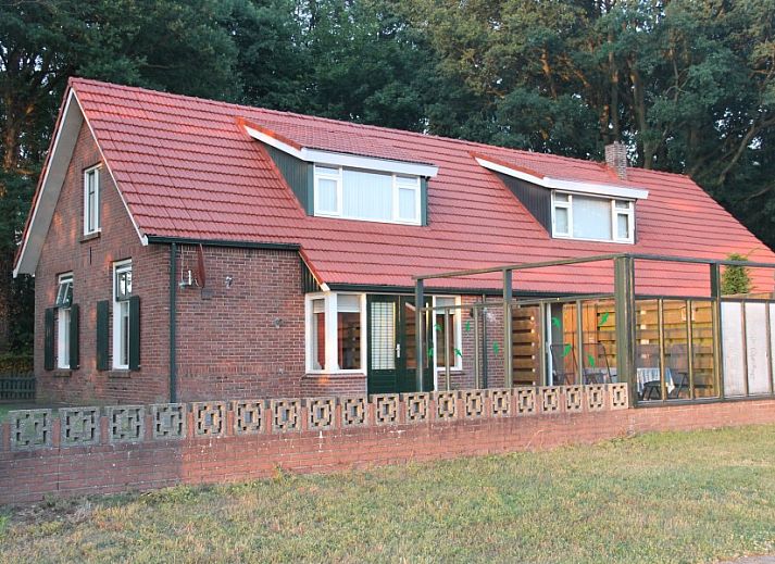 Stijlvolle woonkamer met bloemen in Vakantiewoning Hogeweg, Winterswijk, gelegen in de prachtige Achterhoek.