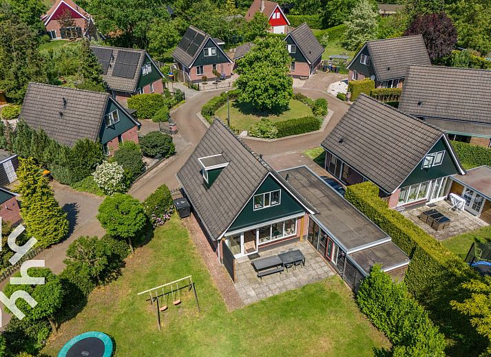Vorderansicht des Ferienhauses DG238 in Winterswijk Achterhoek mit gruener Umgebung.