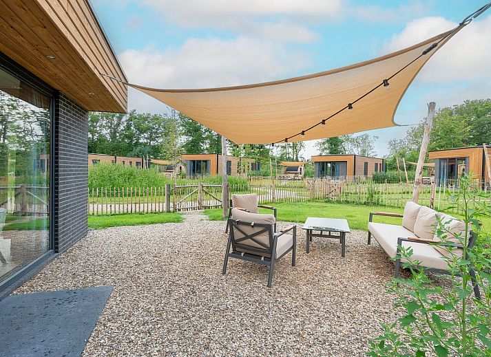 Parklodge 6 in Achterhoek: schaduwrijke zitplek met sauna en hottub in vakantiehuis.