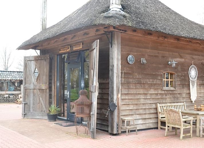 Gezellige binnenruimte van Vakantiehuisje in Ruurlo, Achterhoek, met houten interieur en trap naar bovenverdieping, ideaal voor ontspanning.