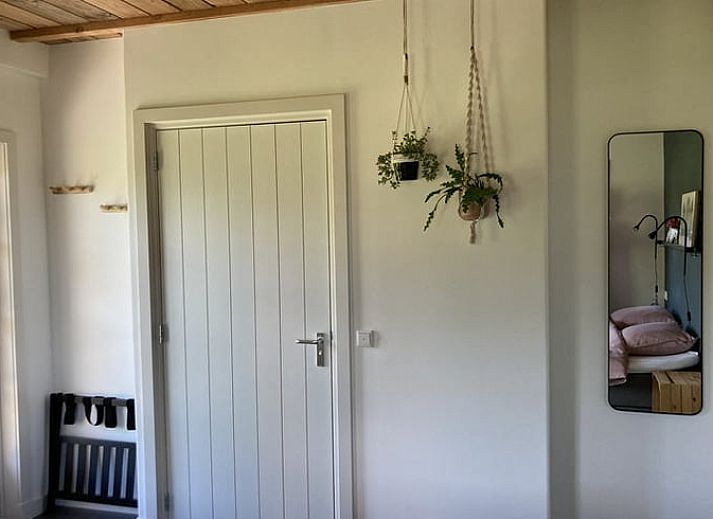 Sfeervolle slaapkamer in Vakantiehuis in Westendorp, Achterhoek, met houten plafond en kunst aan de muur.
