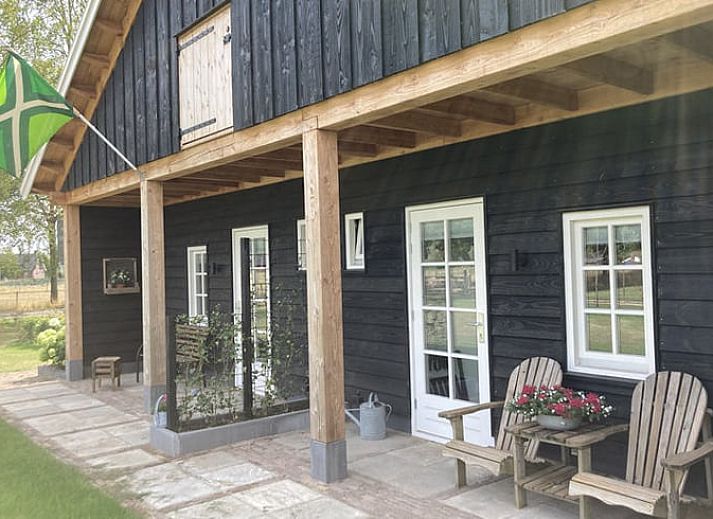 Sfeervolle slaapkamer in Vakantiehuis in Westendorp, Achterhoek, met houten plafond en kunst aan de muur.