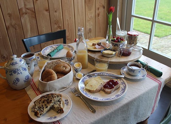 Cozy bedroom in Huisje in Westendorp, bed and breakfast in the Achterhoek, with wooden ceiling and soothing green walls.
