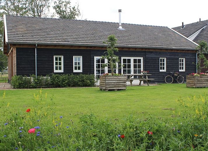 Bright room at Huisje in Westendorp, bed and breakfast in Gelderland, with wooden wardrobe and garden views.