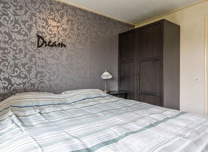 Detail van de eetkamertafel in Huisje in Aalten, vakantiehuis in de Achterhoek, met bloemen en tijdschriften.