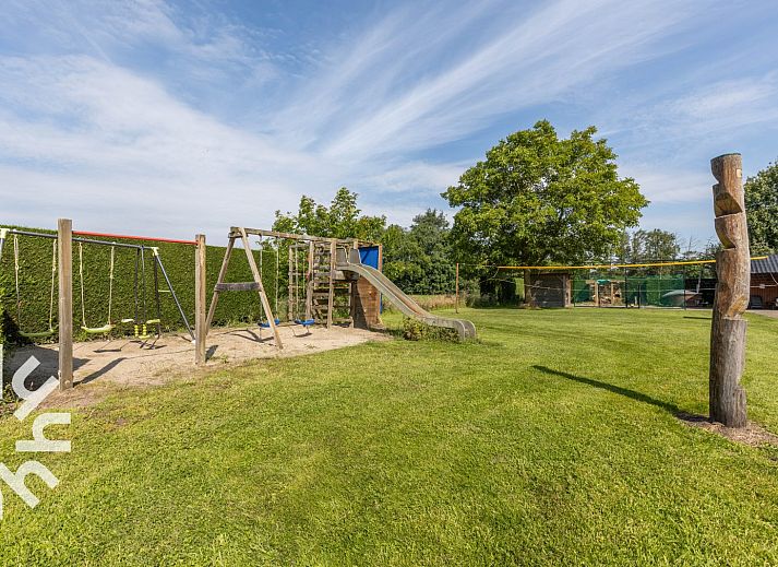 Outdoor play area at DG168 vacation home, Aalten, with trampoline and play equipment.