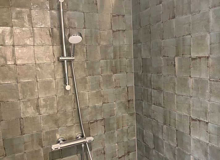 Gemuetliches Wohnzimmer des Ferienhauses in Laren, Achterhoek, Gelderland mit Blick auf den Garten und warmen Holzakzenten.