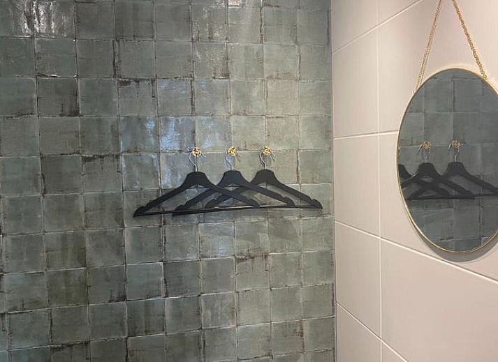 Gemuetliches Wohnzimmer des Ferienhauses in Laren, Achterhoek, Gelderland mit Blick auf den Garten und warmen Holzakzenten.