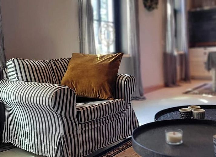 Gemuetliches Wohnzimmer im Ferienhaus in Vragender, Achterhoek, mit bequemem Sofa und Holzbalken.