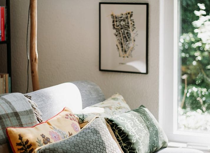Gezellige woonkamer in vakantiehuis in Lochem met open haard en natuurzicht.