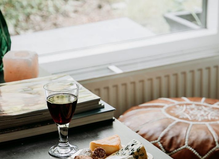 Gezellige woonkamer in vakantiehuis in Lochem met open haard en natuurzicht.