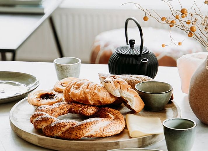 Lichte zithoek in vakantiehuis in Lochem met uitzicht op het groene bos.