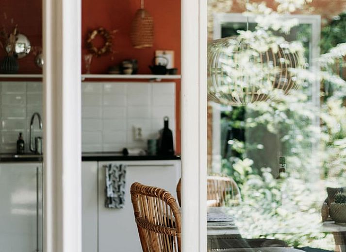Lichte zithoek in vakantiehuis in Lochem met uitzicht op het groene bos.