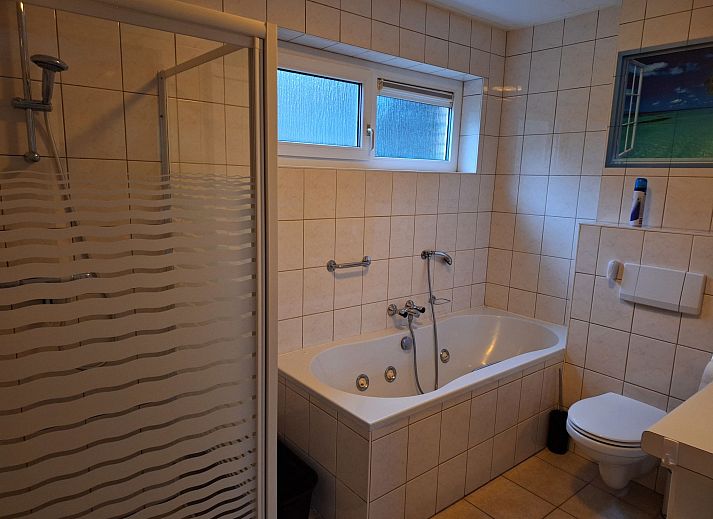 Geraeumige Terrasse des Ferienhauses 4L in Lochem mit Blick auf den gruenen Garten.