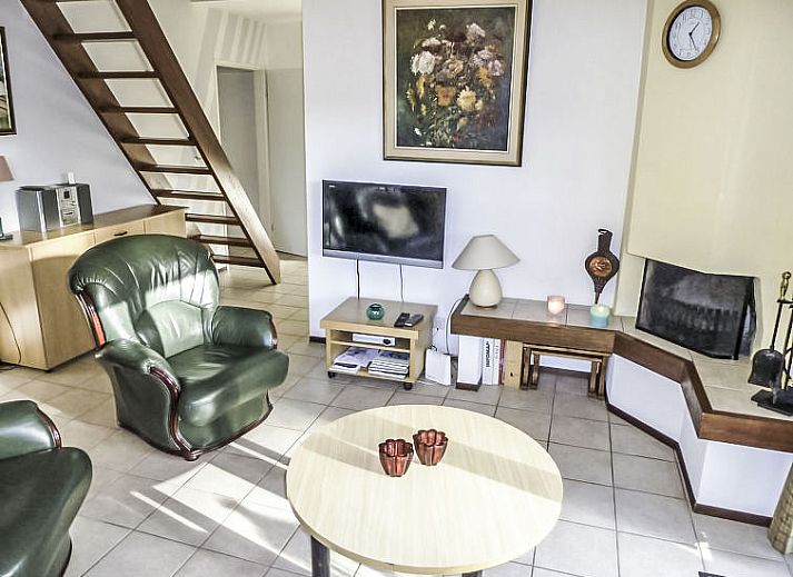 Moderne woonkamer in Vakantiehuis 4L, Lochem met comfortabele banken en open haard voor gezellige avonden in de Achterhoek.