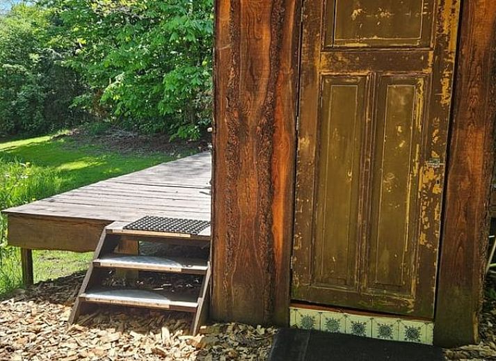 Gemuetliches Wohnzimmer des Ferienhauses in Harfsen, Achterhoek, Gelderland mit Blick in die Natur und bequemer Sitzecke.