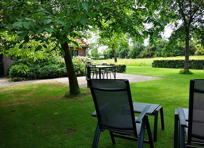 Gemuetliches Wohnzimmer des Ferienhauses in Harfsen, gelegen in Achterhoek, Gelderland, mit Blick auf die gruene Umgebung.