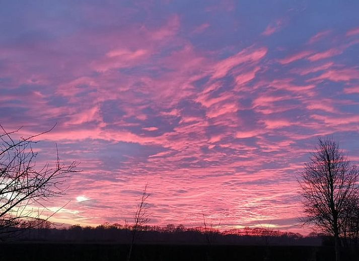 Gemuetliche Kueche und Essbereich im Ferienhaus in Harfsen, Achterhoek, Gelderland, mit Blick auf die gruene Umgebung.
