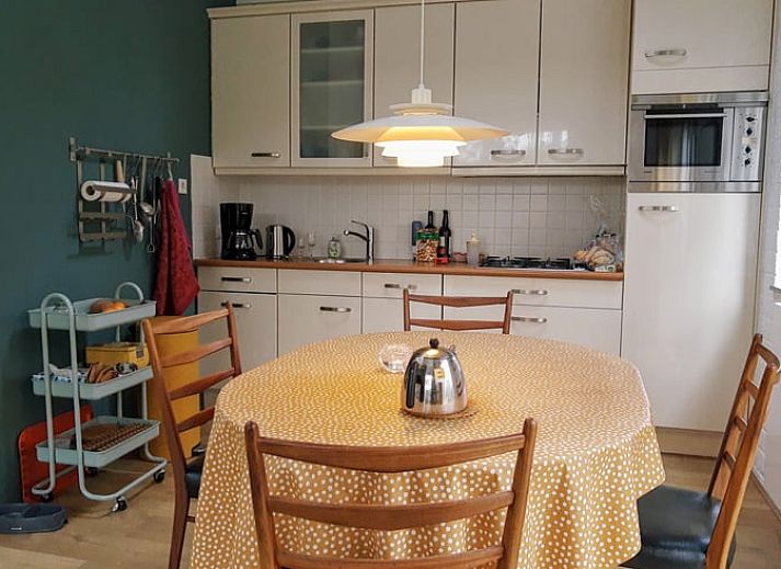 Gezellige keuken en eetruimte in Huisje in Harfsen, vakantiehuis in de Achterhoek, Gelderland, met uitzicht op de groene omgeving.