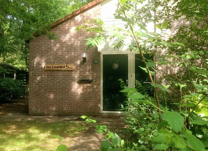 Sfeervolle slaapkamer in Huisje in Harfsen, vakantiehuis in Achterhoek, Gelderland met zonnige gele muur en comfortabel tweepersoonsbed.